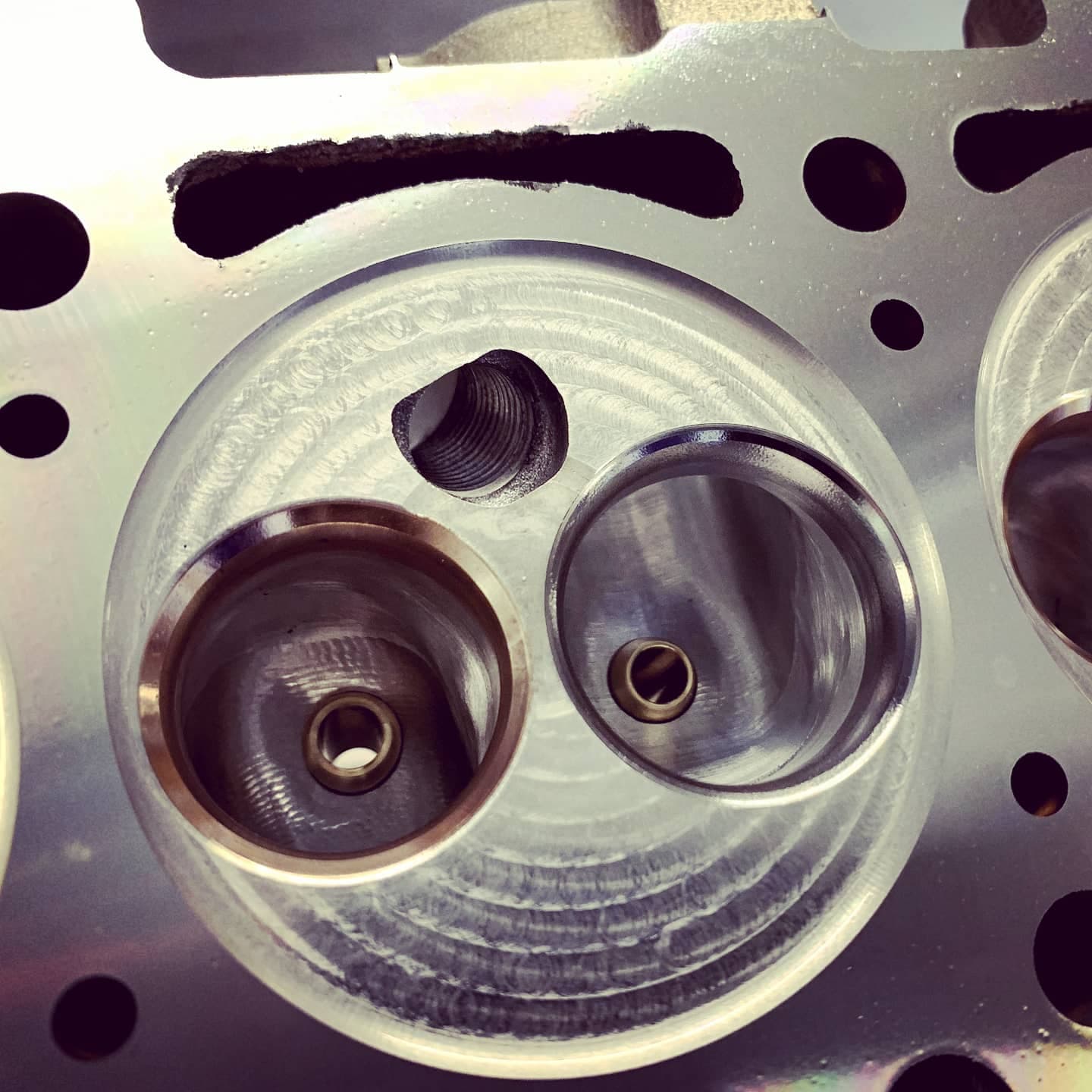 Four CNC-machined combustion chambers of a cylinder head side by side