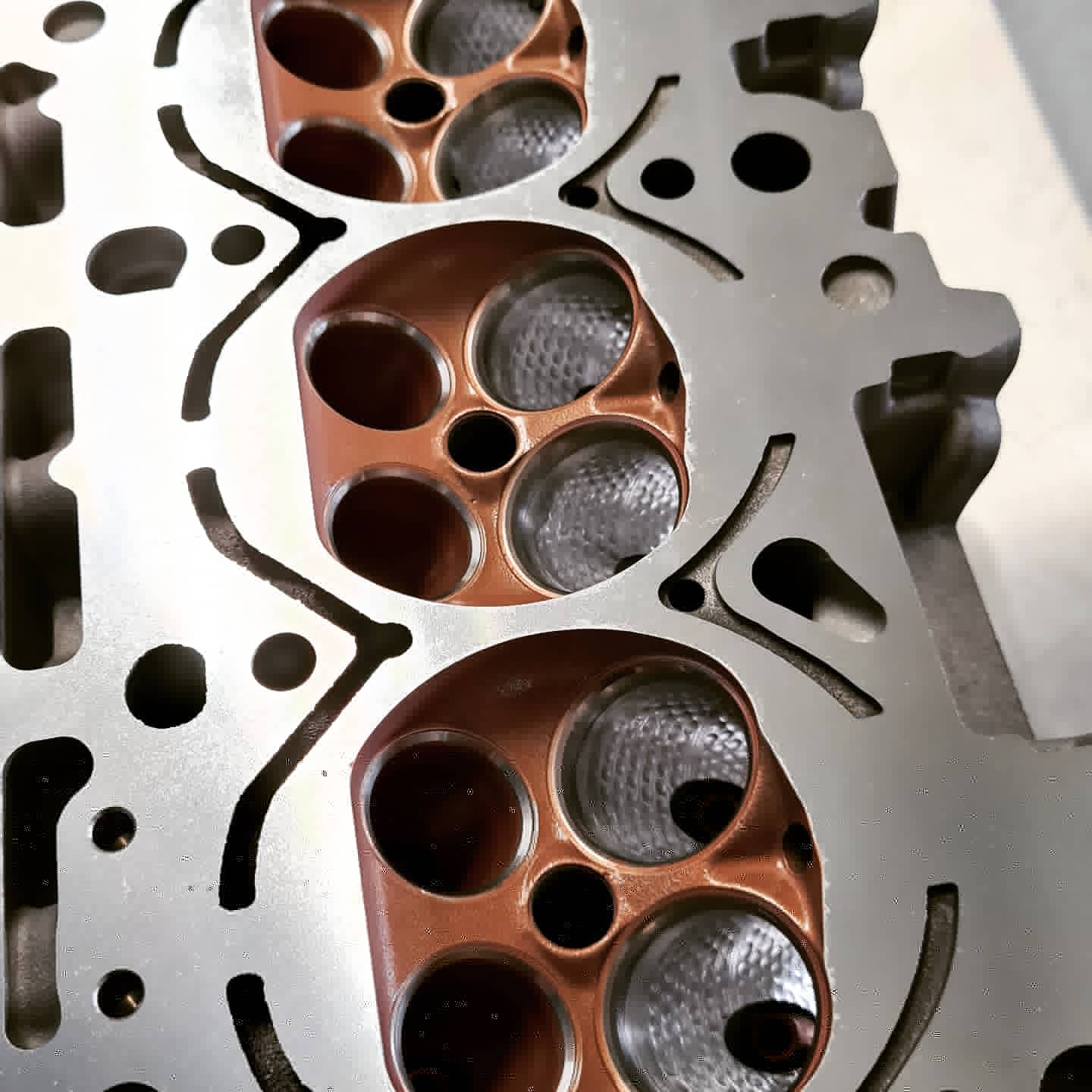Ceramic-coated cylinder head with valves in copper tone, detail view