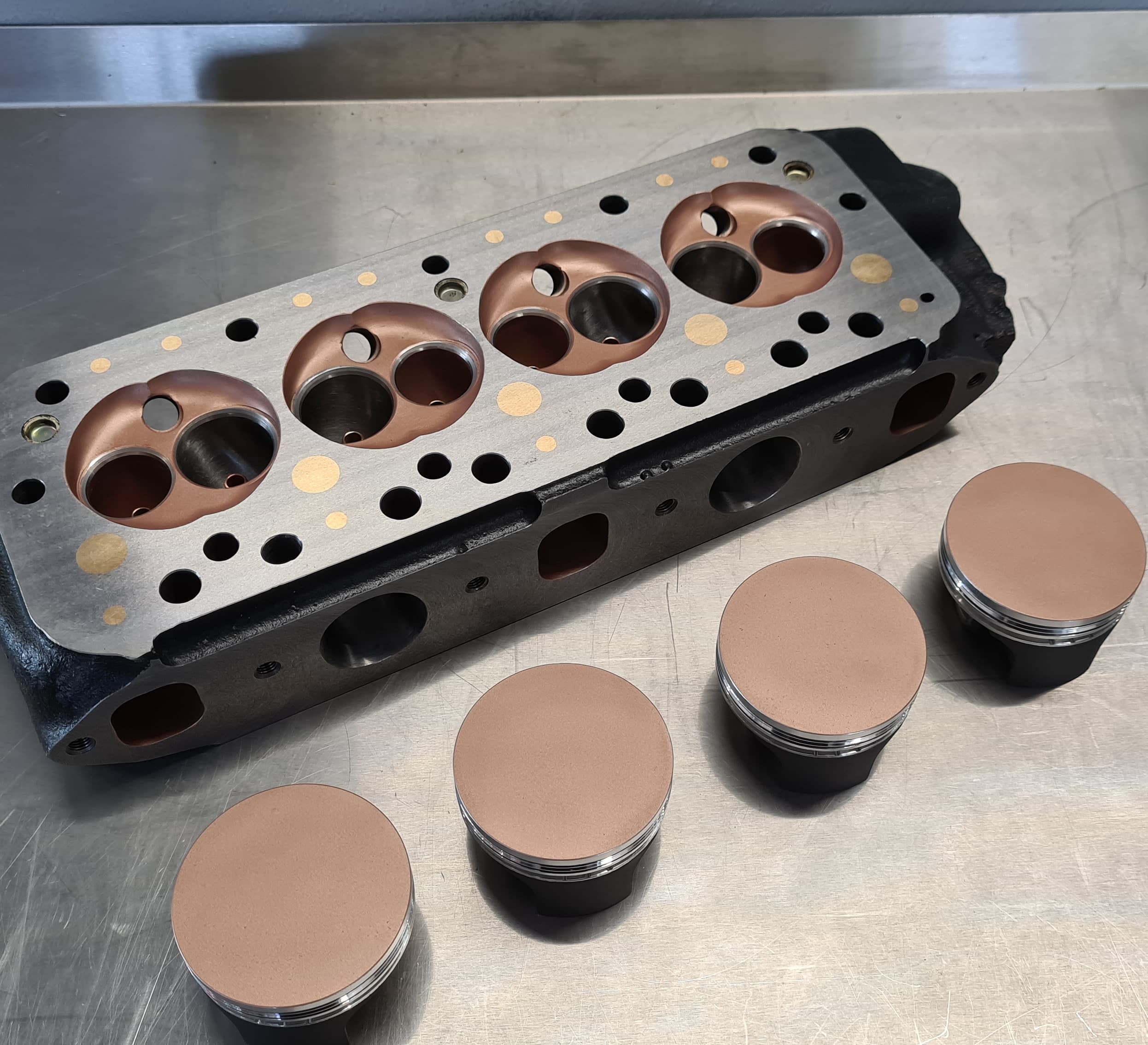 Ceramic-coated cylinder head with several combustion chambers in copper tone