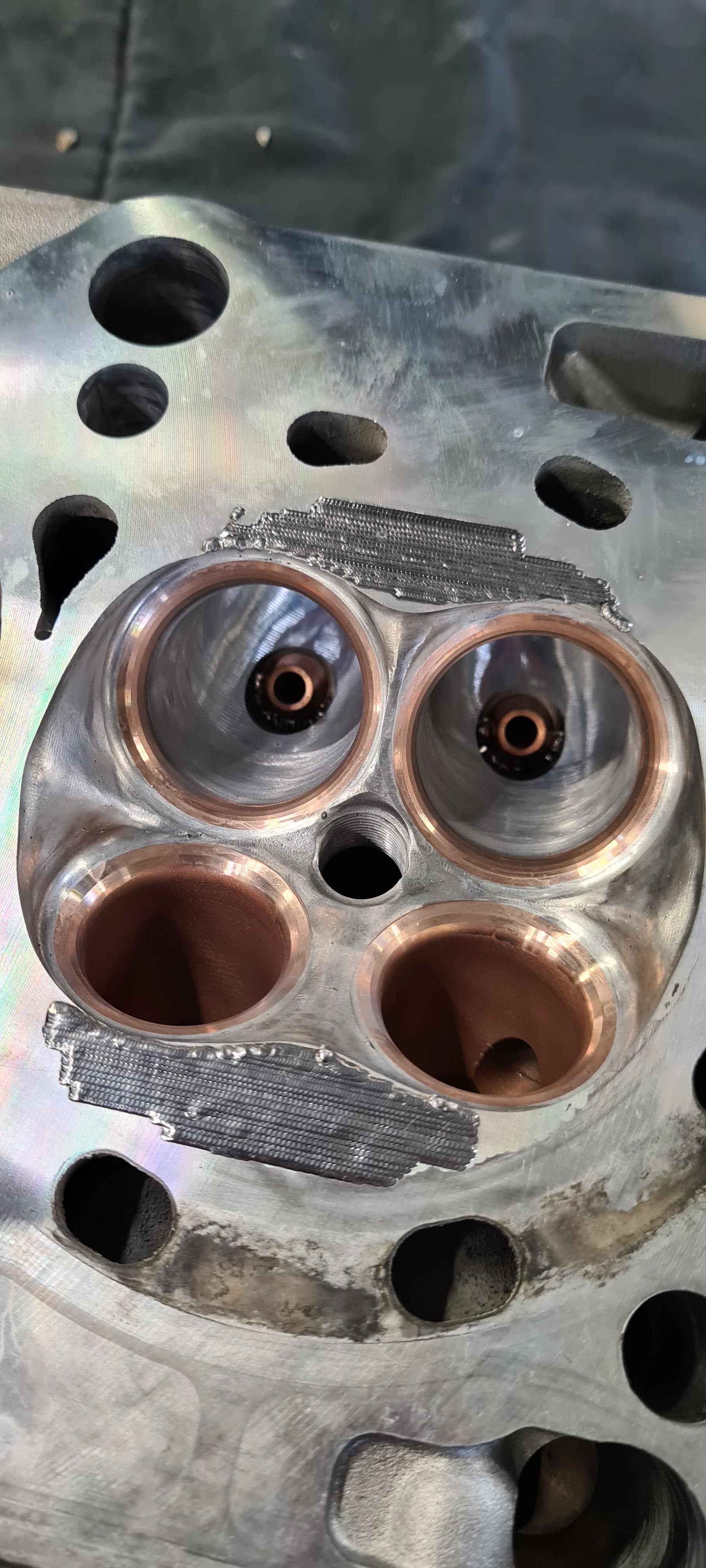 Fresh laser weld seam on a CNC-machined cylinder head combustion chamber