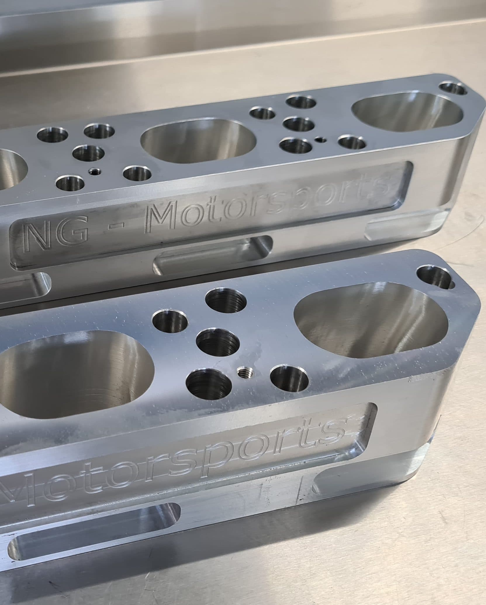 CNC-milled aluminum special component with an engraved NG-Motorsports logo