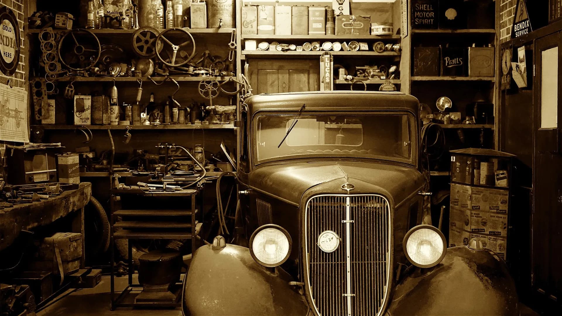 Vintage van in a period workshop, surrounded by shelves with spare parts, oil cans and enamel signs