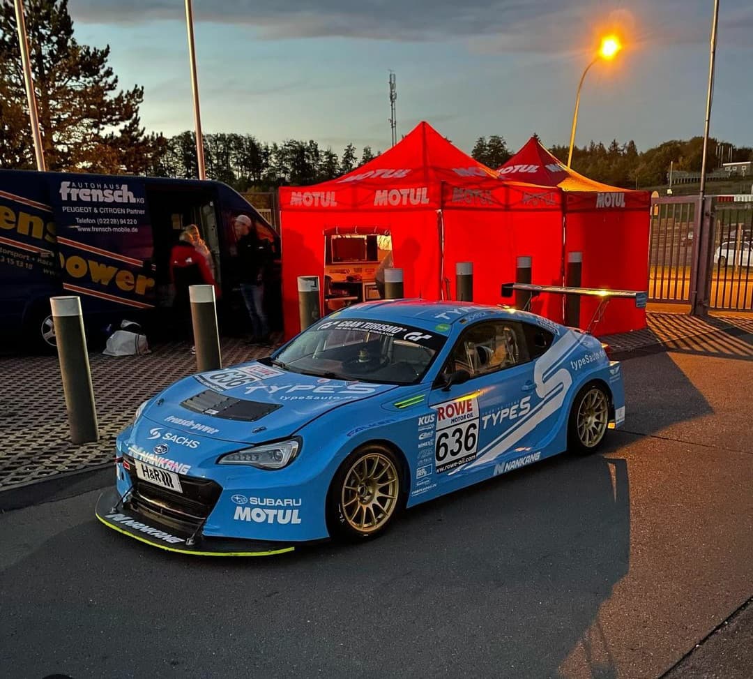 Blauer Subaru-Rennwagen im Fahrerlager einer Rennstrecke