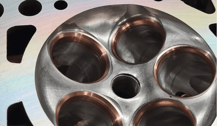 CNC-machined combustion chambers and valve seats of a cylinder head, close-up