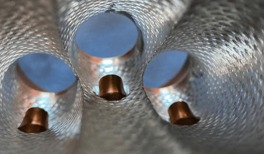 Close-up of a CNC-machined cylinder head port with a bronze valve seat ring