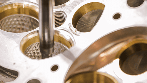 Gold-toned coated valve seats after CNC machining, close-up