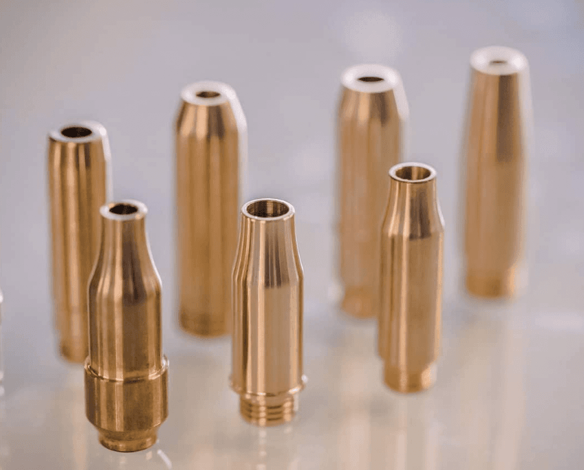 Six gold-toned UltraFlow bronze valve guides on a white background